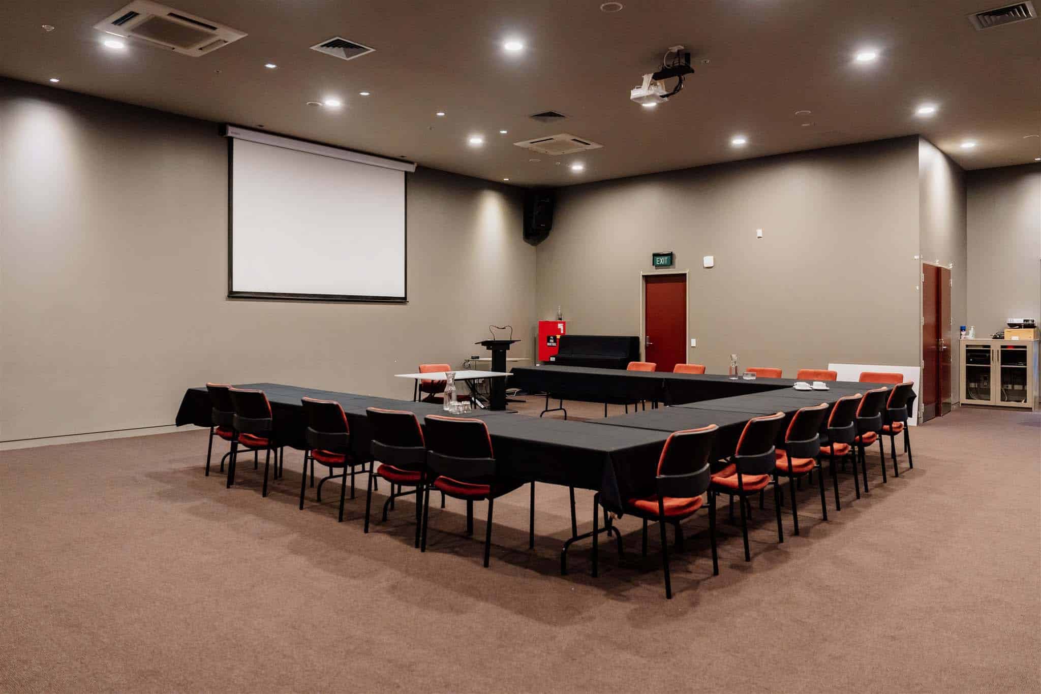 A conference room set up with chairs and a projector screen.