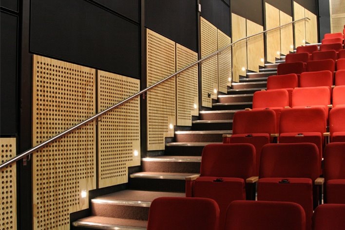 An auditorium with red seats and stairs.