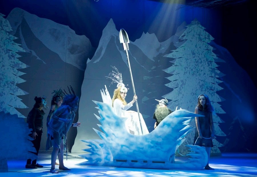 A group of people on a stage in front of a snow scene.