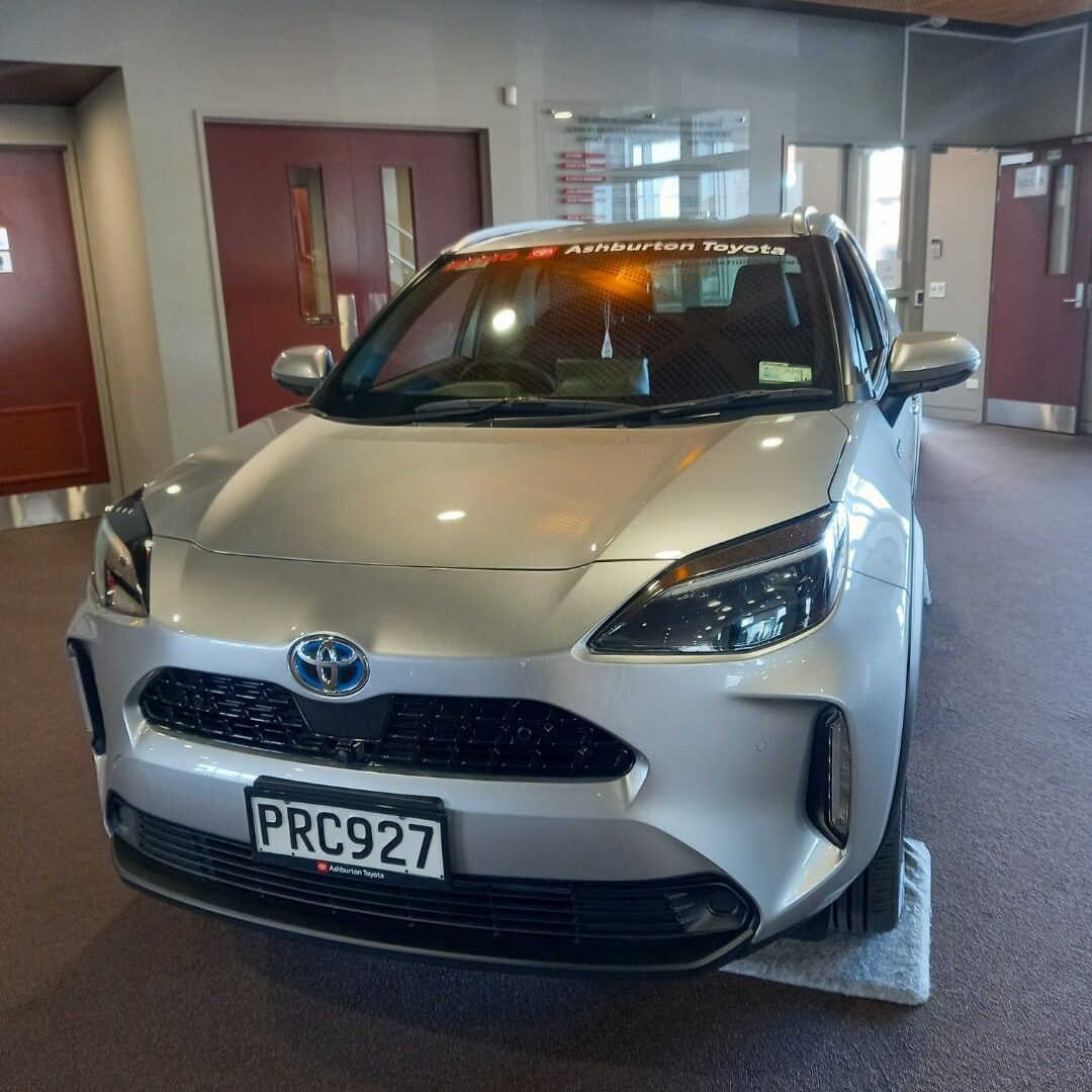A silver toyota c-hr is parked in a building.
